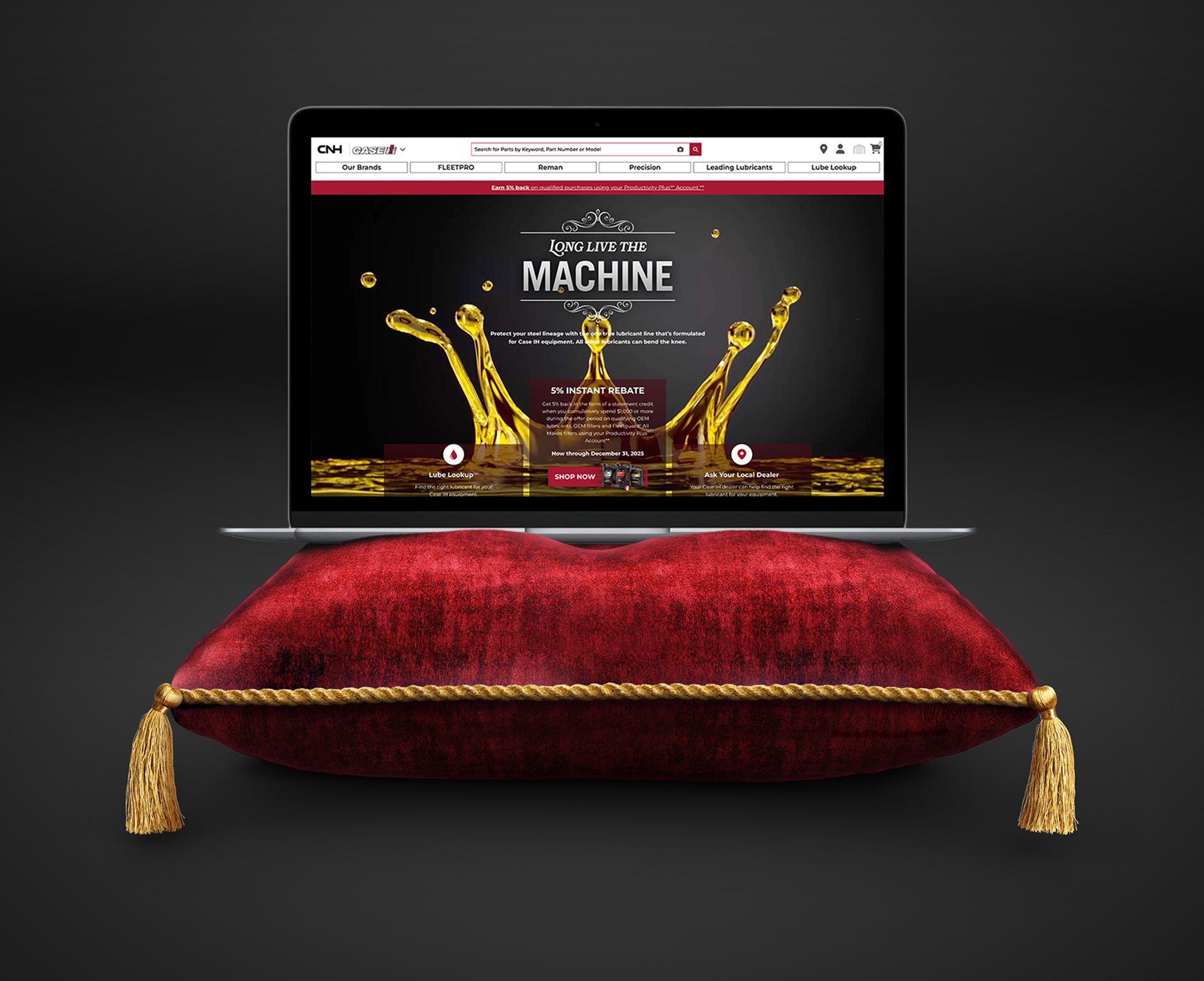 Laptop on a red velvet pillow, displaying the CNH 'Long Live the Machine' website.