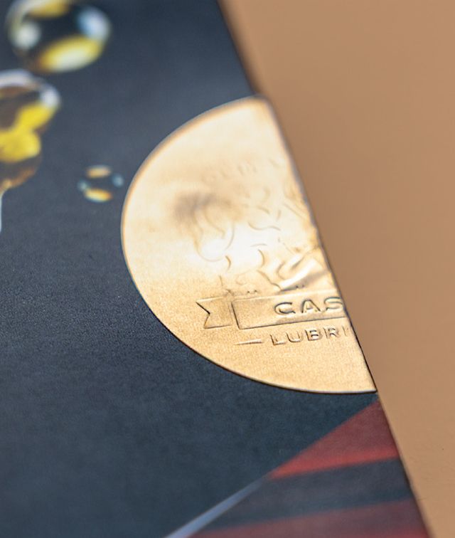 Close-up of a promotional flyer, showing a gold half-circle design with 'CASE IH LUBRICANTS'.