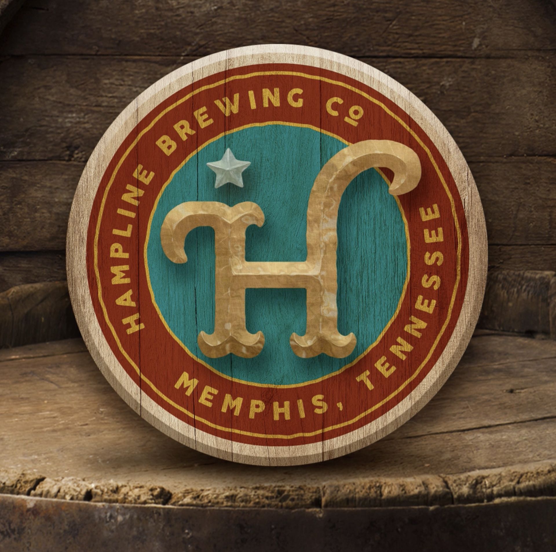 Round wooden Hampline Brewing Co. logo with a stylized 'H' and stars, set against a teal background.