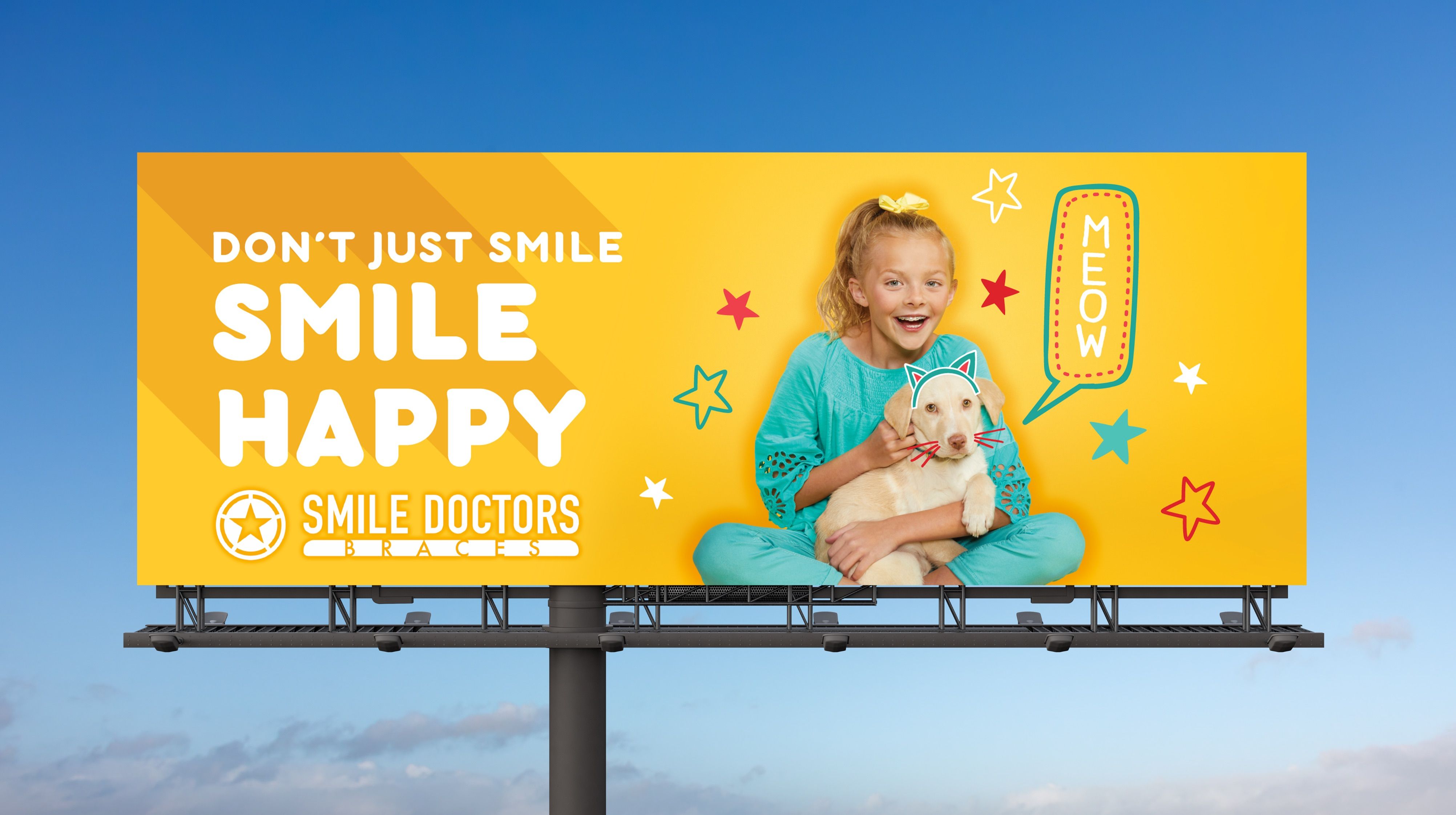 Outdoor billboard reading "Don't Just Smile. Smile Happy." showing a girl hugging a puppy on a yellow background with playful star doodles and the Smile Doctors Braces logo.