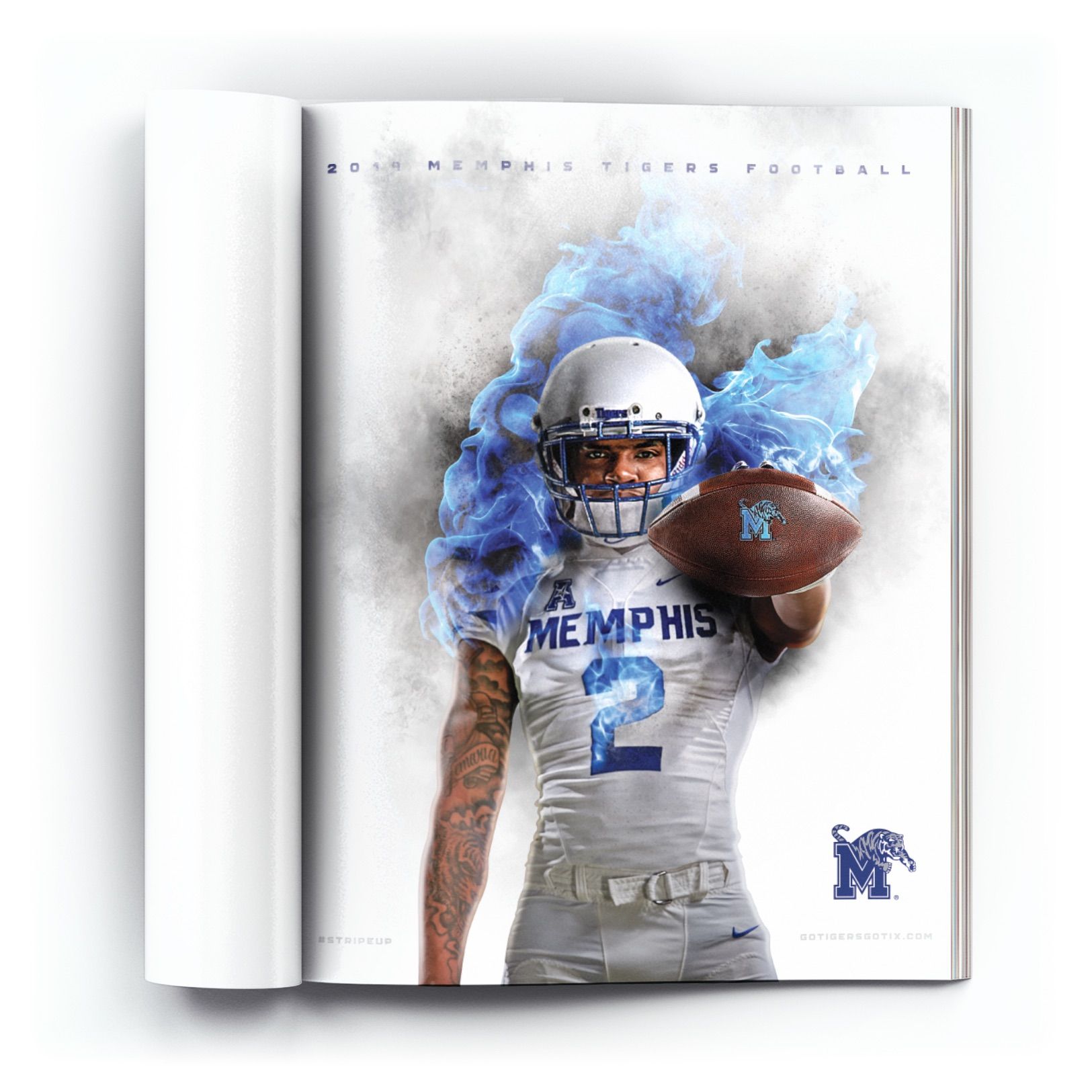 Open magazine spread showing Memphis Tigers quarterback #2 engulfed in blue fire effects holding a football, headlined "2019 Memphis Tigers Football" with a gotigersgo tix.com call to action.